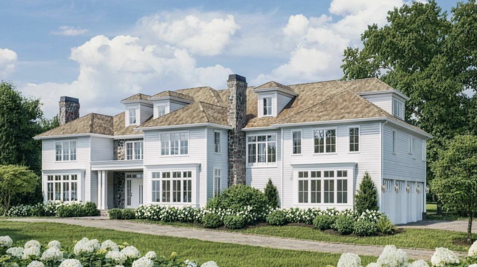 Large white-sided Greenwich, Connecticut home with stone chimneys, dormers, a cedar-toned roof, a covered front entry, white hydrangeas along the drive and a multi-bay garage